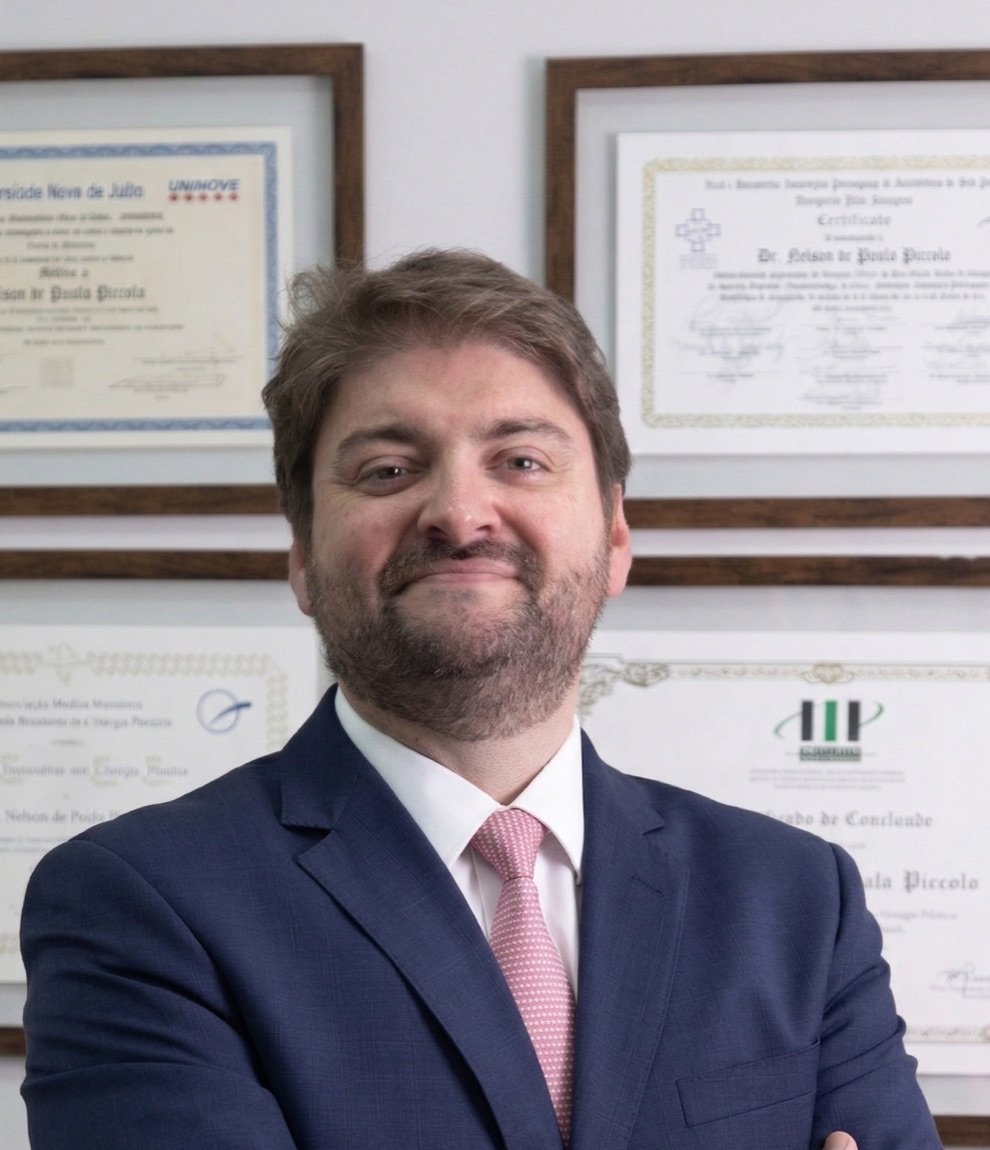 Dr. Nelson Piccolo, cirurgião plástico, diante de seus diplomas e títulos